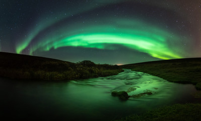 Northern lights with reflection in river, North Iceland