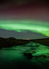 Northern lights with reflection in river, North Iceland