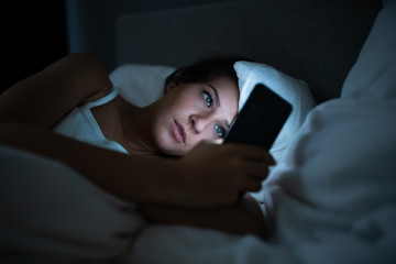 Woman In Bed With Mobile Phone