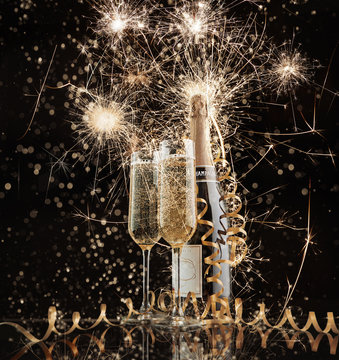Glasses and bottle with champagne against fireworks. New Year