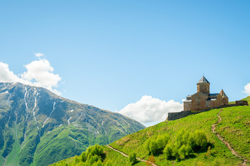 The Caucasus Mountains and the Trinity Church on a mountain in Georgia are a beautiful landmark in the village of Gergeti