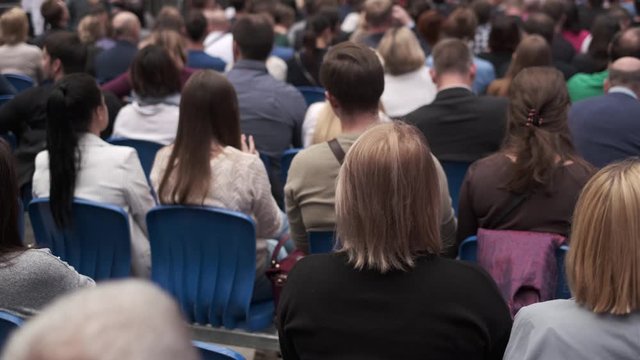 Business conference attendees sit and listen
