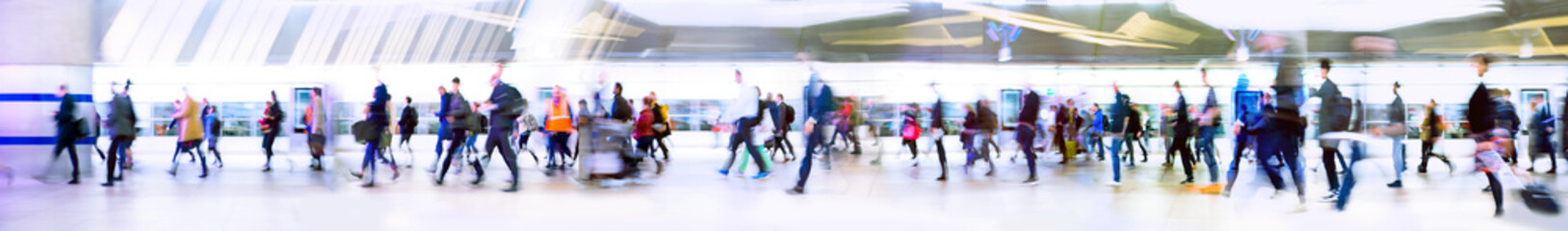 Lots of business people walking through big open space. People on the way to work, rushing via the underground tunnel. London, UK