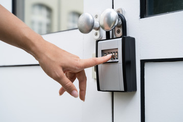 Woman Using Key Safe To Retrieve Keys