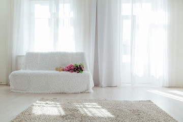 sofa with gifts in the interior of the white room with a window