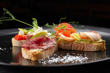 Brusquettes, Assorted, Fish, Prawns, Meat, Vegetables, Seafood, on a black background