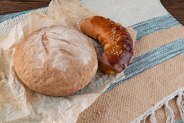 Homemade fresh round bread and one croissant with filling. Delicious homemade pastries. Close up.