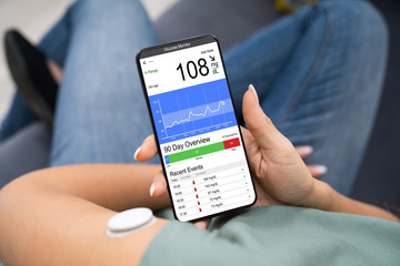 Woman Checking Blood Sugar Level On Smart Phone