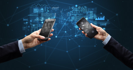 Close up of two hands holding smartphones to sync business data