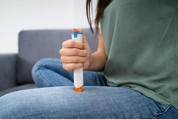 Woman Injecting Epinephrine Using Auto-injector Syringe
