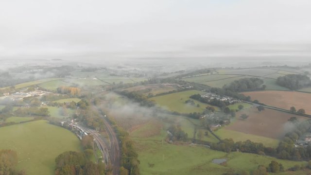 Aerial drone shot of a misty / foggy green landscape of British countryside