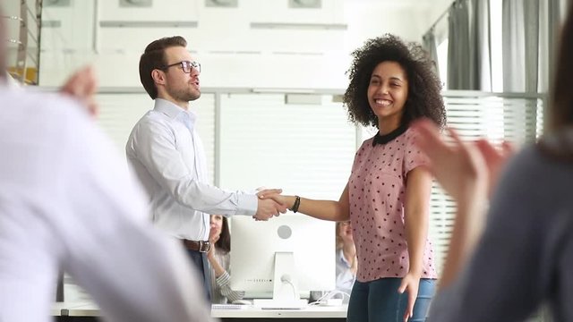 Staff cheering employee of month boss shaking hands express gratitude