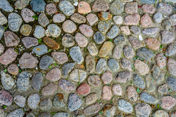Stone background of pavement with rough granite boulders. Medieval cobble paving