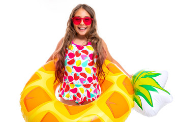 girl with long crucified hair in sunglasses and swimsuit stands in a rubber ring and smiles isolated on white background
