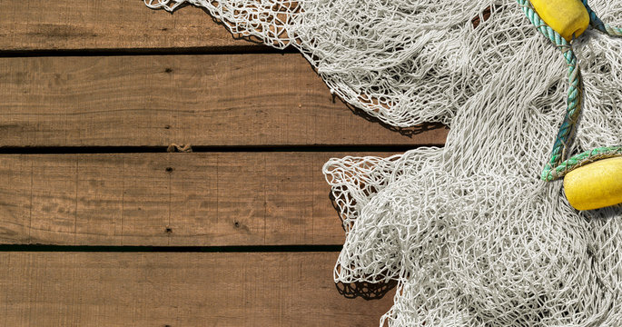 Fishing net on wooden deck background with copy space