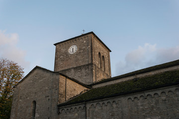 Fototapeta premium Tower with clock on an ancient romanesque church 