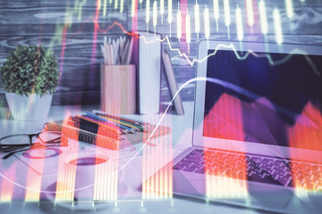 Stock market graph on background with desk and personal computer. Multi exposure. Concept of financial analysis.