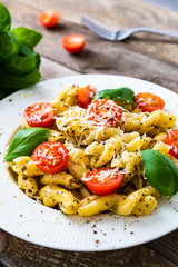 Pasta with cherry tomatoes and cheese on wooden table