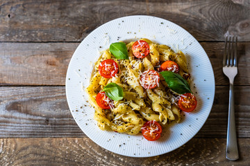 Pasta with cherry tomatoes and cheese on wooden table