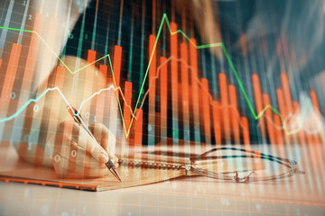 Multi exposure of woman's hands making notes with forex graph hologram. Concept of technical analysis.
