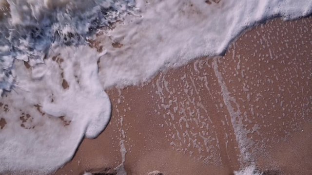 White foam from the seething waves of the sea evenly fills the background.