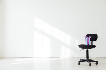 black office chair with a gift in an empty white office