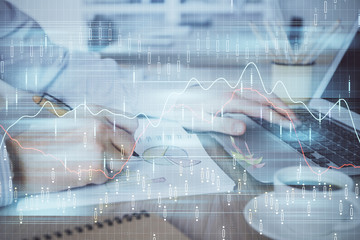 Multi exposure of stock market graph with man working on laptop on background. Concept of financial analysis.