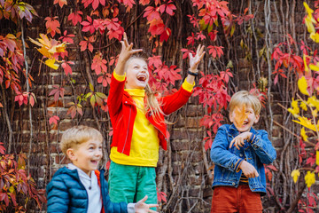 three cute siblings together outside with bright colored background