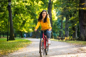 Rolgordijnen Urban biking - woman riding bike in city park © Jacek Chabraszewski