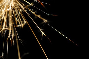 Fototapeta premium Close-up of golden sparkles of a burning fire