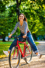 Urban biking - woman riding bike in city park