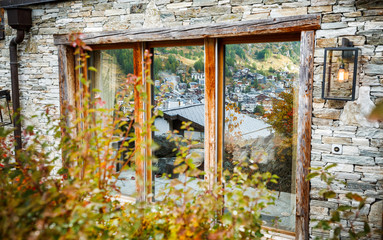 Wide window of luxury hotel with classy view on Zermatt, Swiss luxury ski resort. Autumnal scenery.