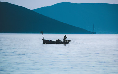 Silhouette of fisherman and boat at the sea