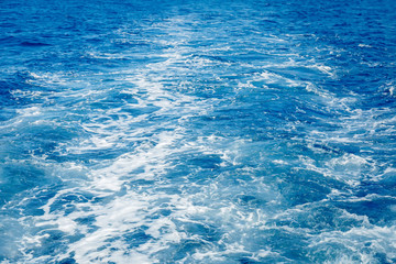 Blue sea surface background with splashing waves