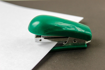 green stapler with wthite paper