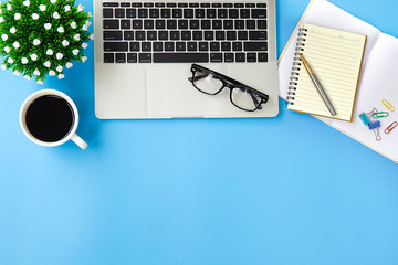 Top view desk ,Modern office desk Workplace with laptop computer, coffee cup, glasses,notebook and...