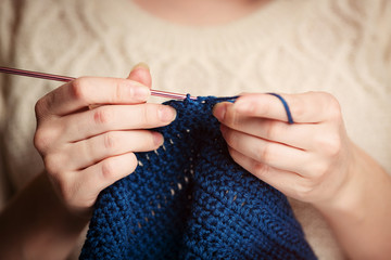 Young Woman in Sweater Knitting with Crochet Hook
