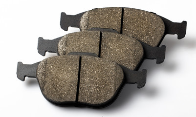 Three brake pillows on a white background are arranged in a row. New parts for the repair and maintenance of the car's brake system.