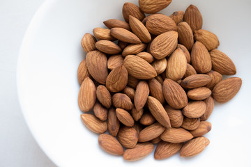 Almonds kernels on a white plate.
