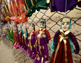 Colorful Rajasthani puppets hanging in the shop of Jaisalmer City Palace in India