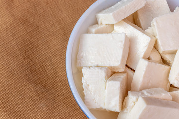 Paneer cottage cheese close up, slice pieces of homemade fresh white raw panner cheese.