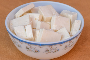 Paneer cottage cheese close up, slice pieces of homemade fresh white raw panner cheese.