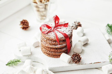 Christmas cookies and marshmallows on a white background by the window