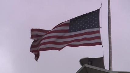 AMERICAN FLAG AND POW MIA FLAG AT HALF STAFF ON WINDY DAY