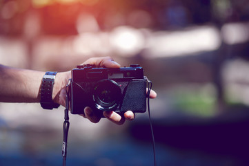 Hand and camera of the photographer Travel in the mountains and nature Concept photographer
