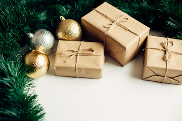 Christmas composition. Fir tree branches, gift boxes, shiny balls on white background. Flat lay, copy space.