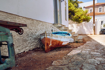 Old boat sitting in front of a house on Greek island Hydra