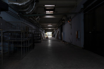 Fototapeta na wymiar Long dark corridor in an old industrial building