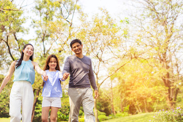 Fototapeta premium Parent families, children walking hand in hand happily in the park