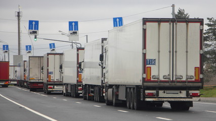  A many trucks with semi-trailers in the queue traffic to the quarantine control point in the warehouse